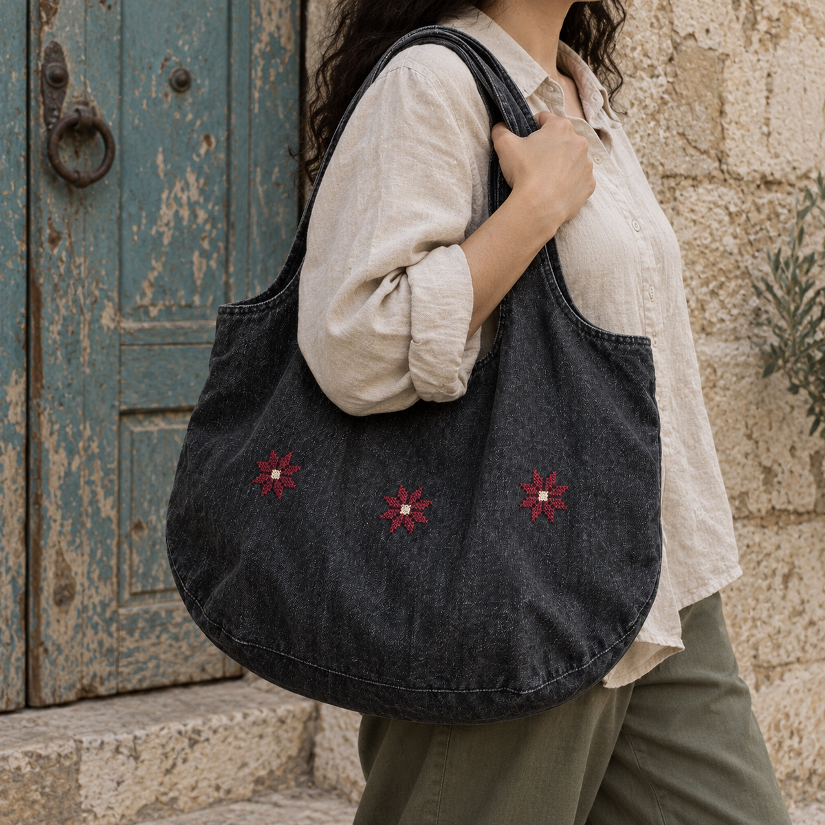 Charcoal denim Bethlehem star tote worn over one shoulder with broad denim handles