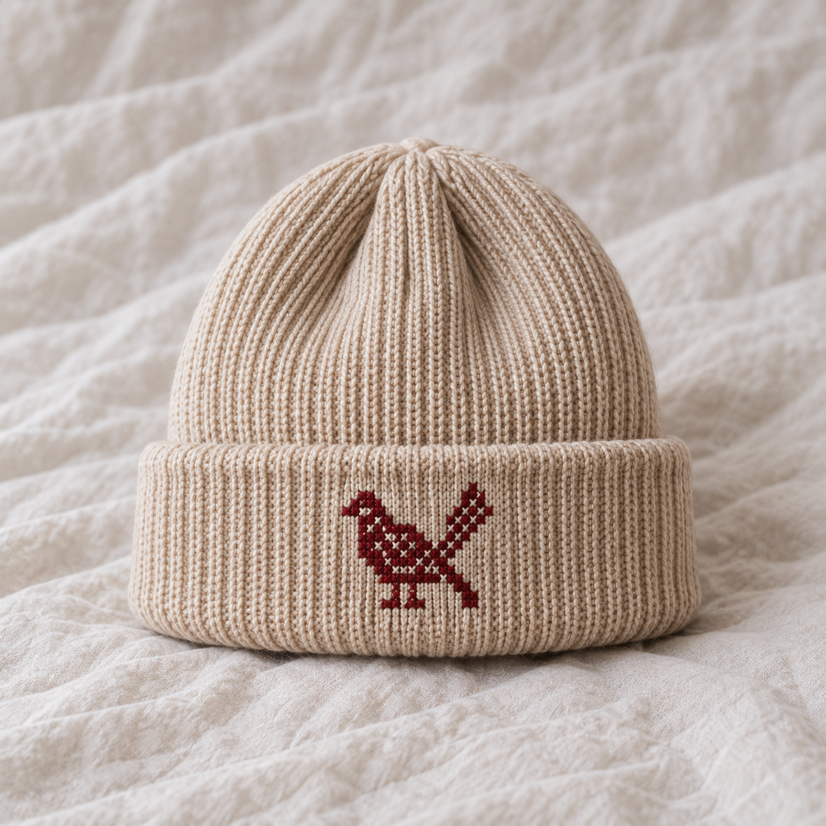 Small2.5cm burgundy stepped folk bird in profile fine X stitches directly on cuff no patch.