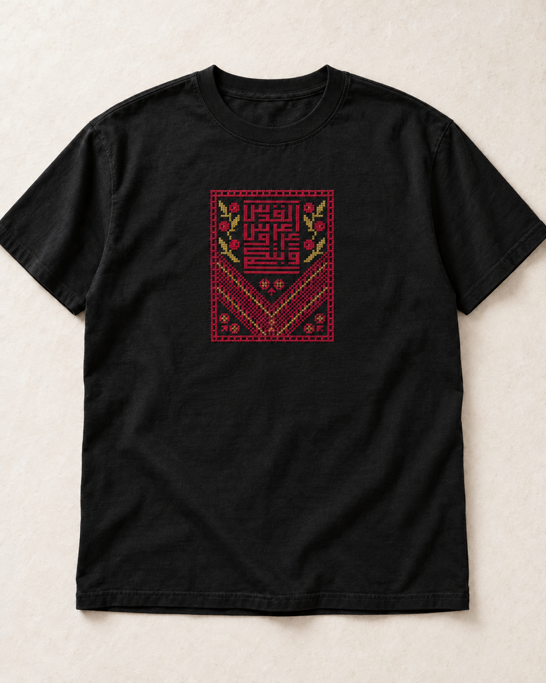 Black Kufic Floral Tatreez T-Shirt with burgundy and muted gold embroidery, flat lay