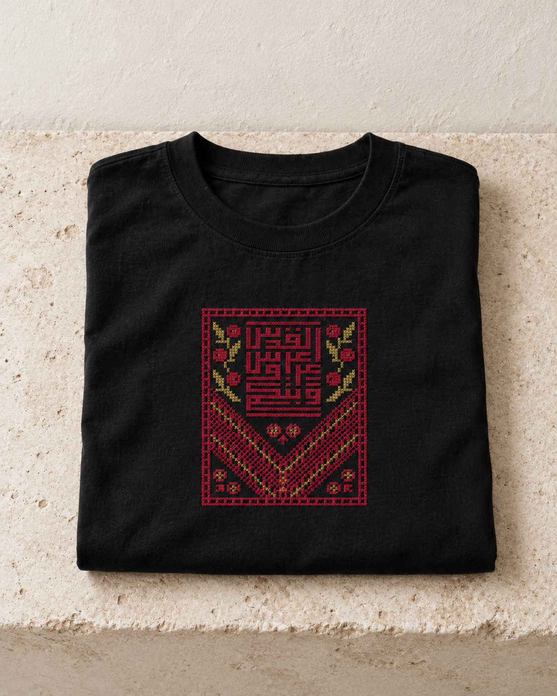 Folded black Kufic Floral Tatreez T-Shirt showing the embroidered chest panel