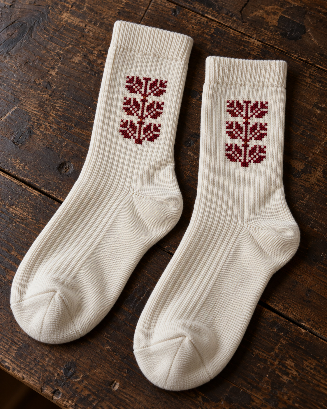 Design mock-up of coffee bean tatreez socks in cream, showing cross-stitch details.