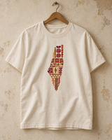 Cream Palestine motifs tatreez map T-shirt hanging against a plaster wall.