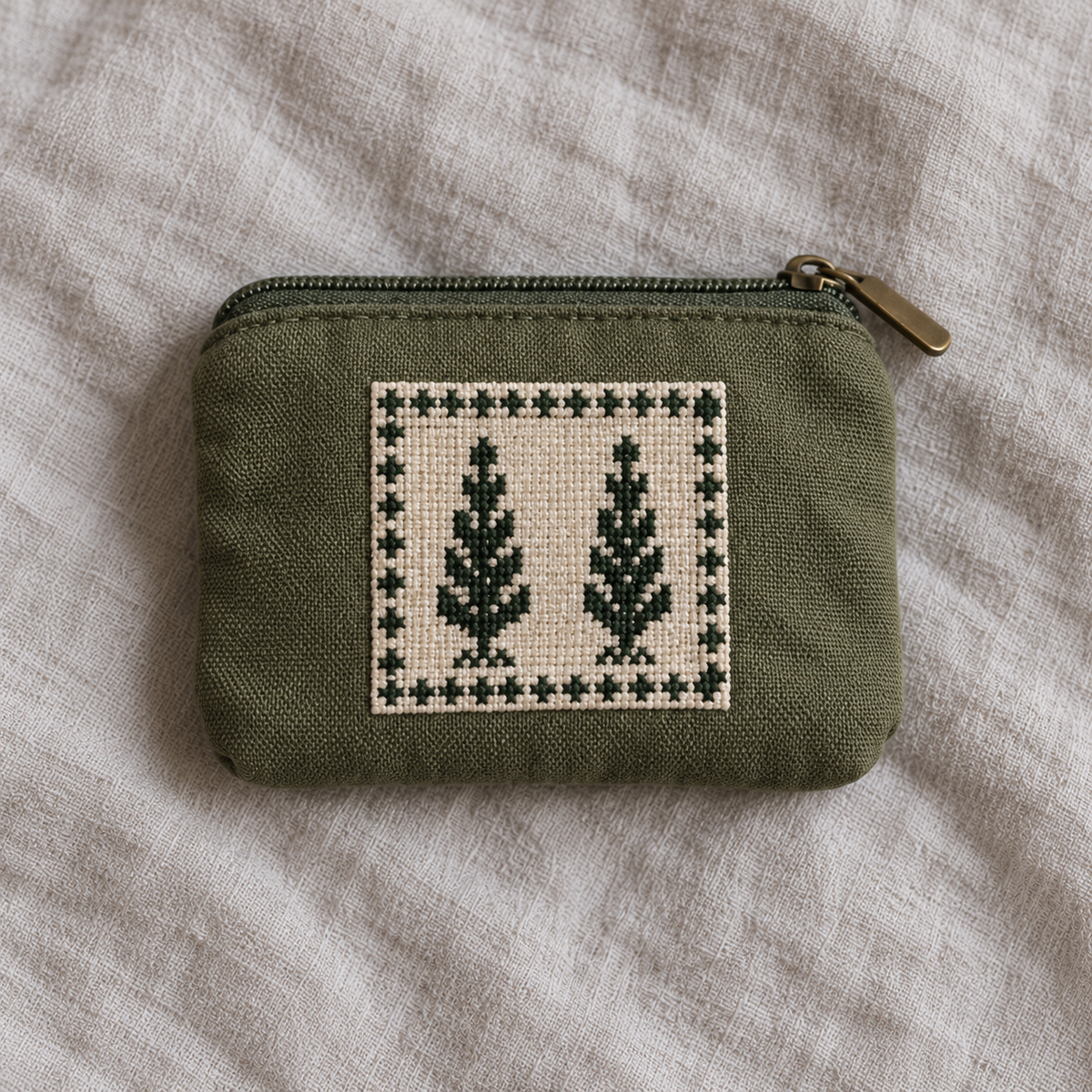 Olive canvas coin purse with two green cypress trees stitched on an ivory panel