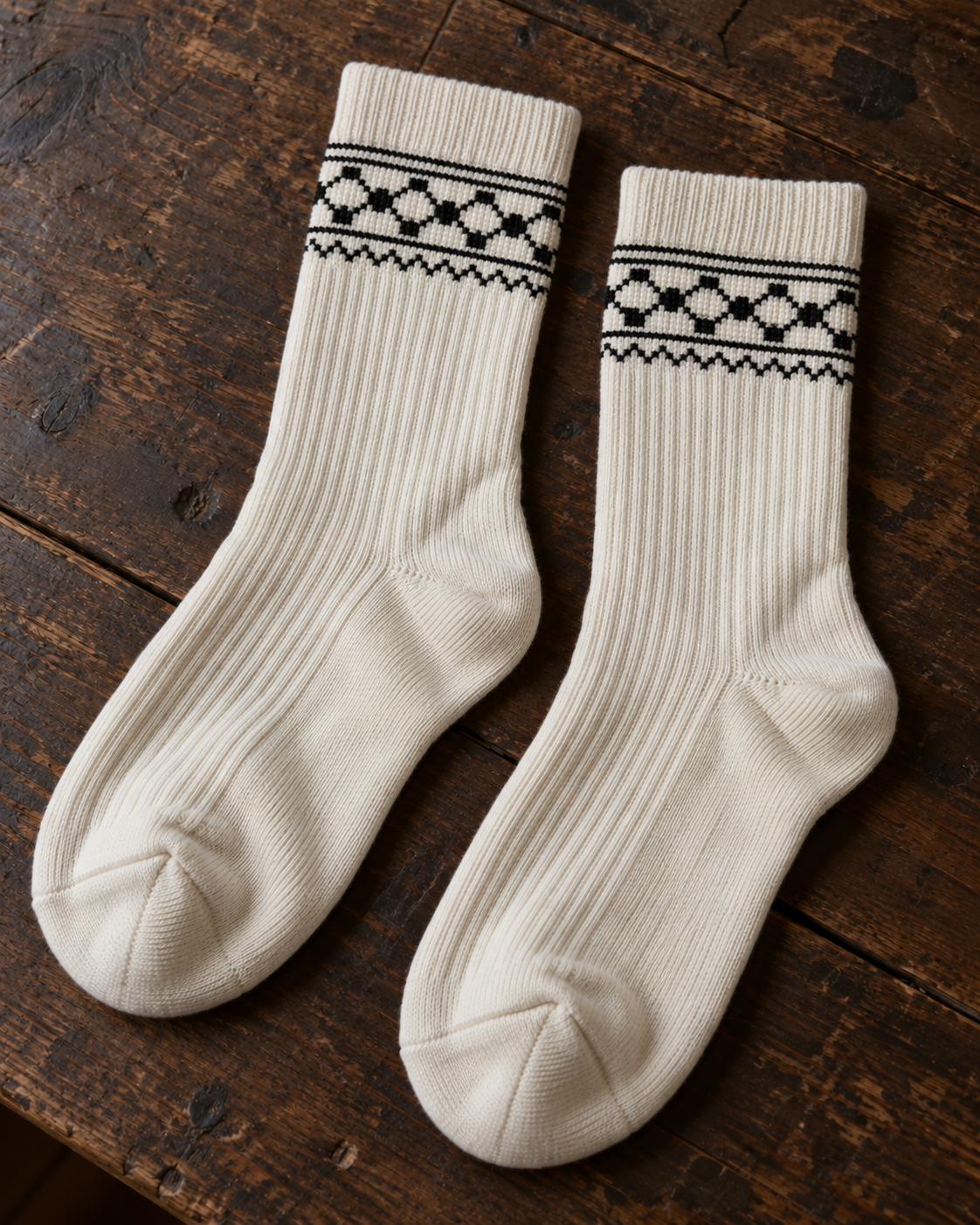 Design mock-up of keffiyeh tatreez socks in cream, showing cross-stitch details.