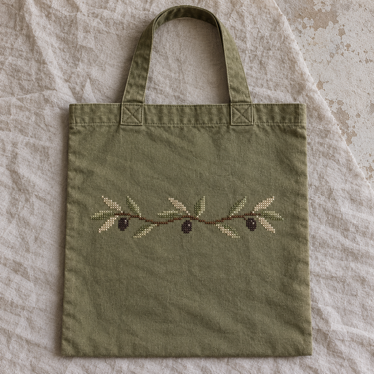 Olive cotton flat tote with a stitched olive branch