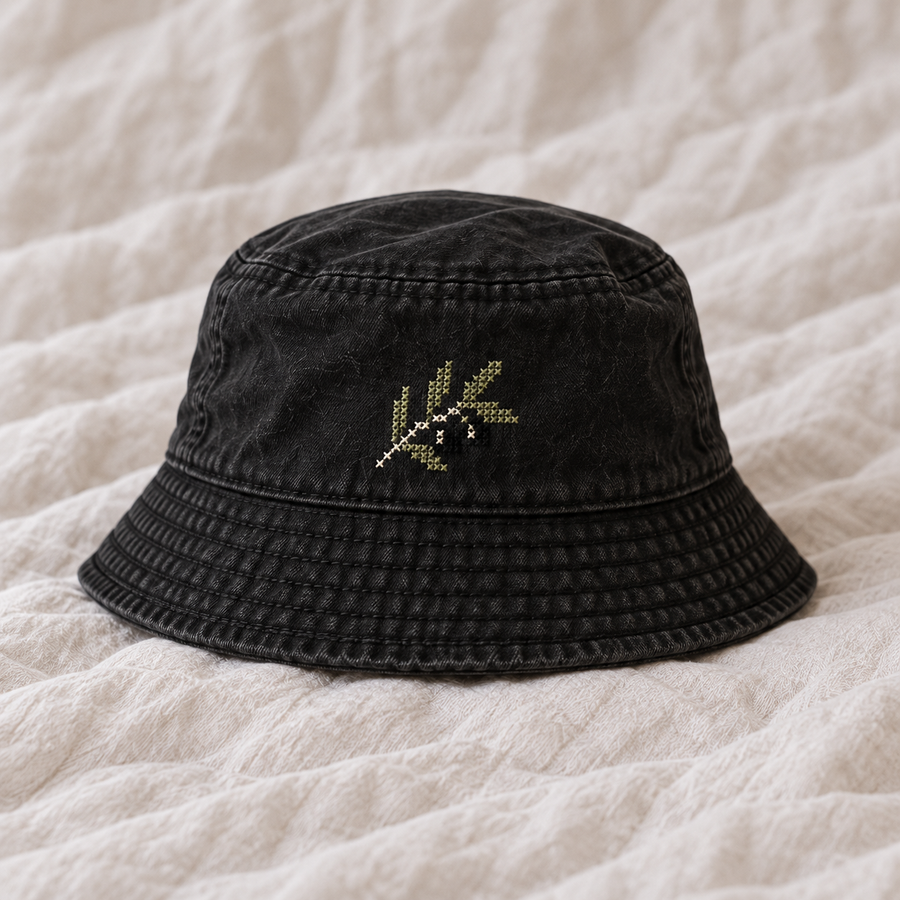 Small understated olive branch green black ivory entirely fine counted cross stitches on black cotton crown.