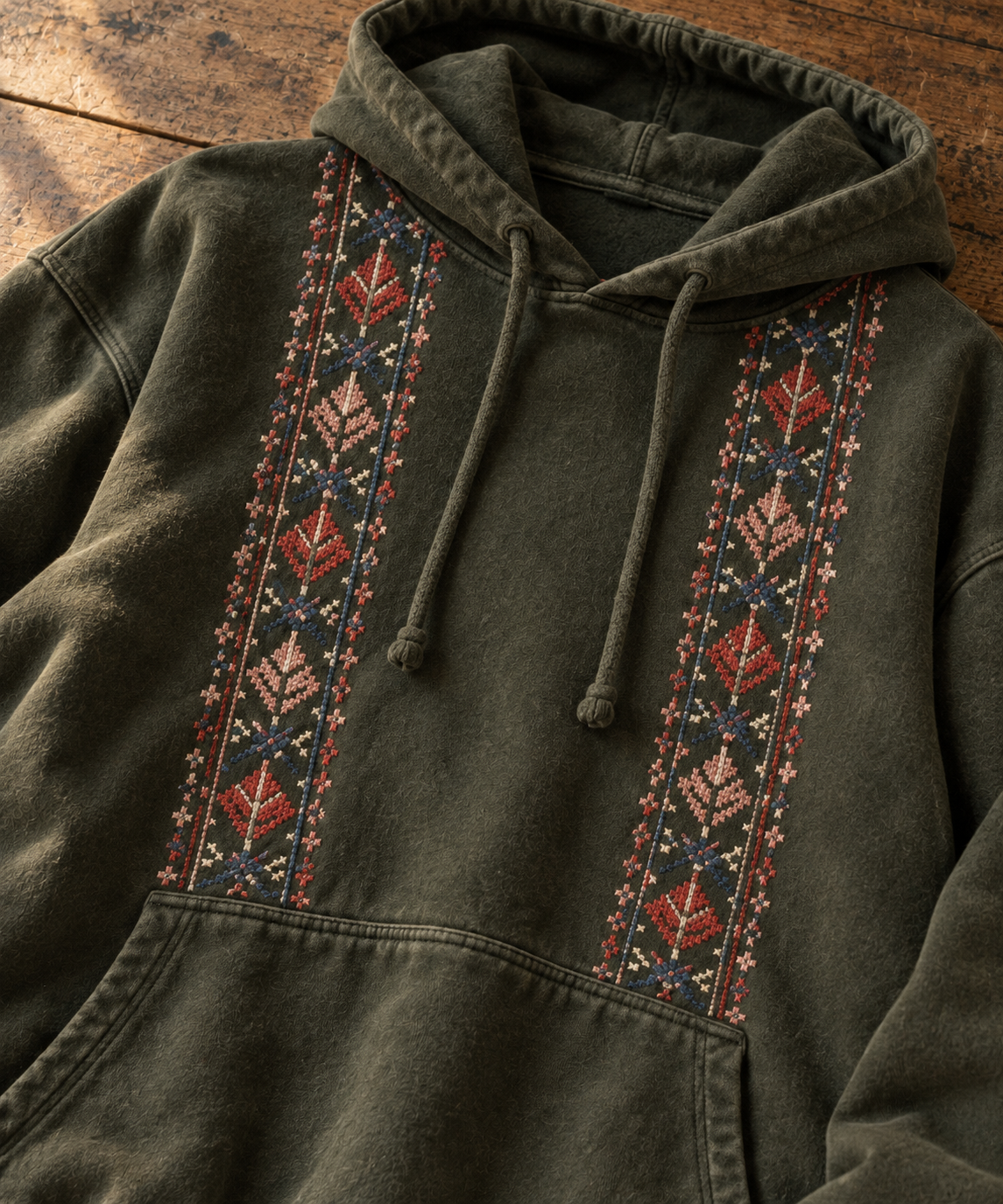 Close-up of the two embroidered tatreez panels on an olive hoodie.