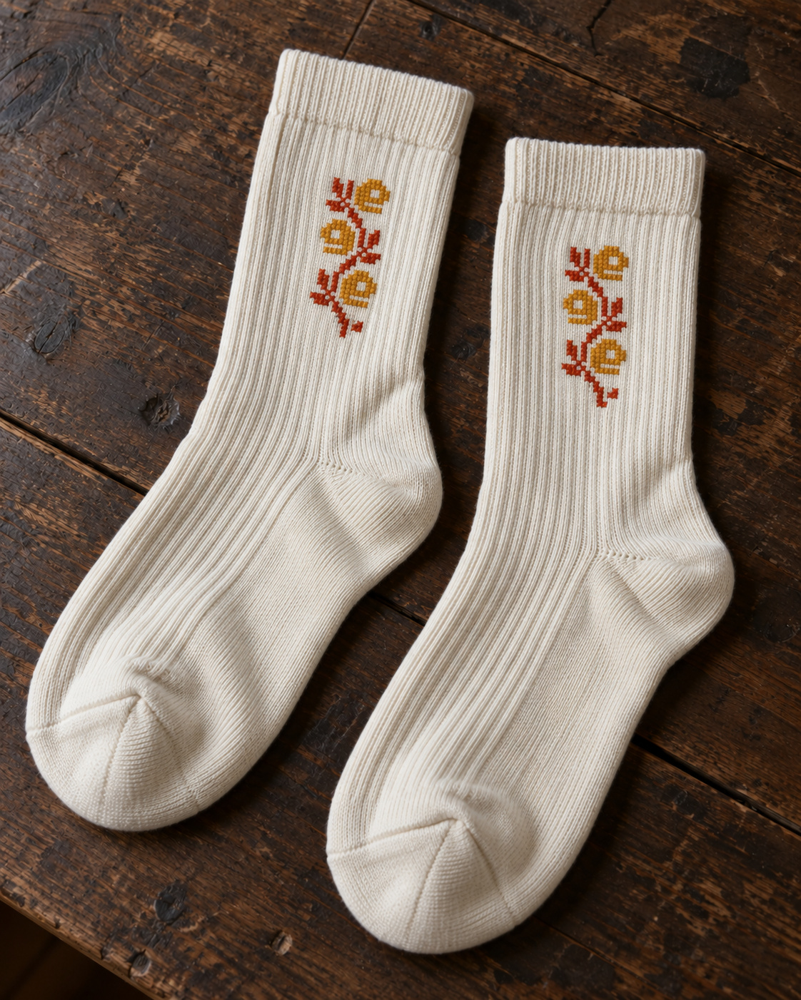 Design mock-up of jaffa orange blossom tatreez socks in cream, showing cross-stitch details.