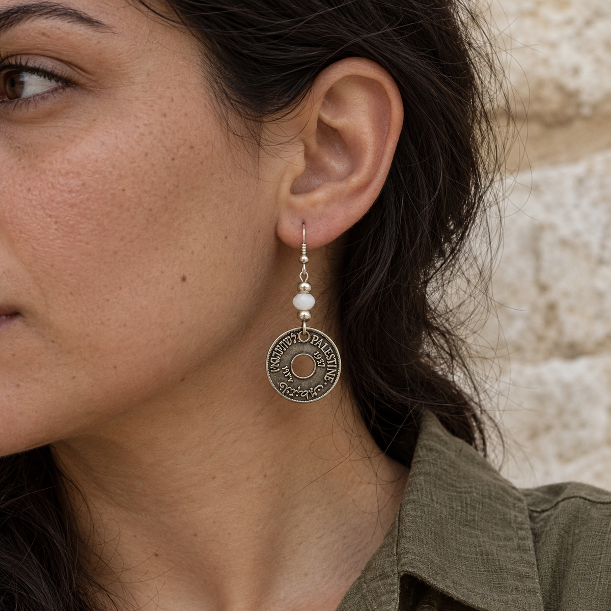 Small Palestine coin earring with faceted white bead worn on a model