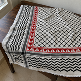 Black and white Palestinian keffiyeh with red triangle tatreez along two adjacent borders