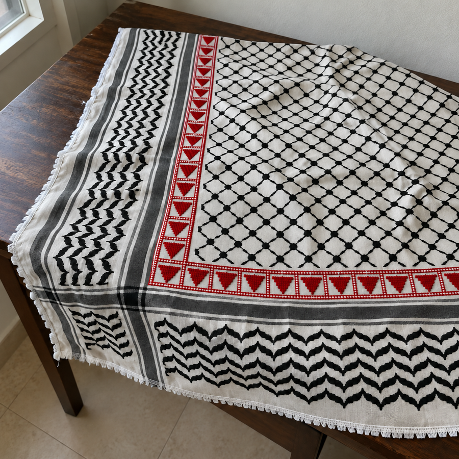 Black and white Palestinian keffiyeh with red triangle tatreez along two adjacent borders