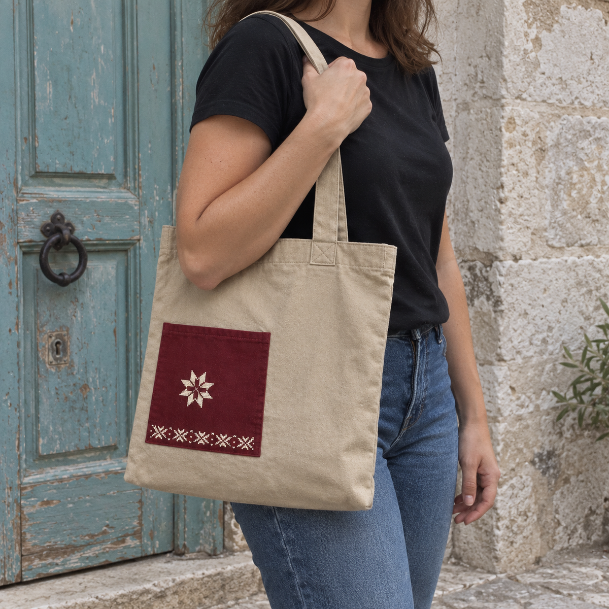 Standard-size sand canvas star pocket tote carried over a woman's shoulder with natural strap drape