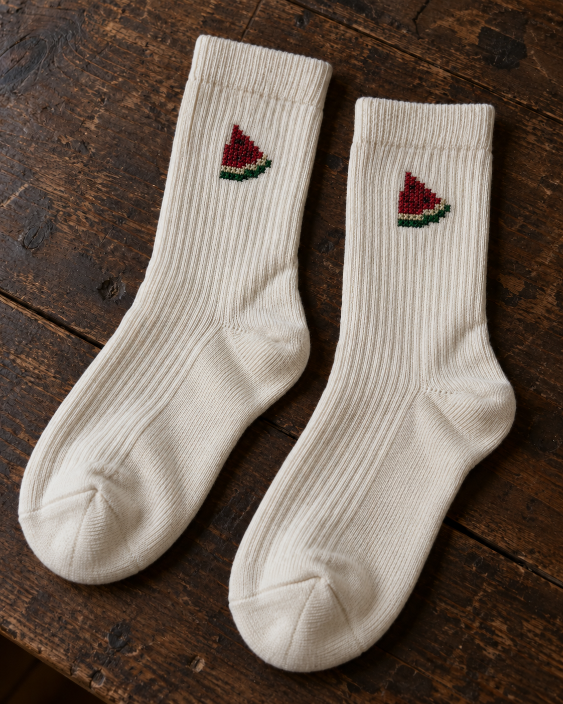 Design mock-up of watermelon tatreez socks in cream, showing cross-stitch details.